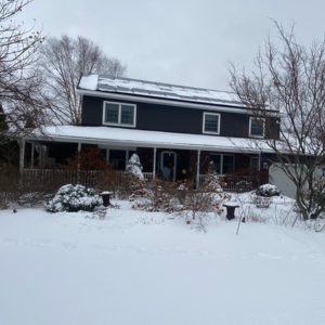 Image of a two story suburban home in upstate new york, surrounded by snow.
