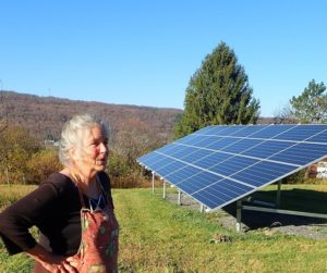 karen kerney stands near the new solar panels on her property